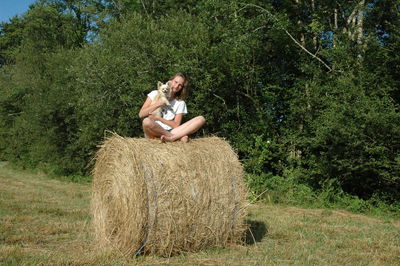 Young woman sitting on hay