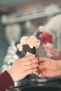 Woman buying couple scoops of ice cream in a candy shop by street. woman putting scoops of icecream