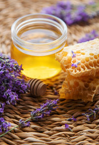 Glass of honey, honeycomb and lavender flowers