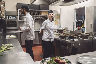 Portrait of smiling chef with coworker in kitchen restaurant