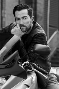 Portrait of man sitting on motorcycle outdoors