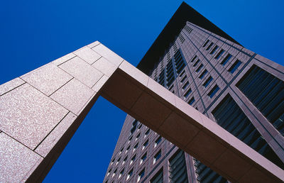 Low angle view of office building against blue sky