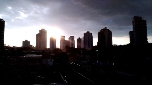 View of skyscrapers in city against cloudy sky