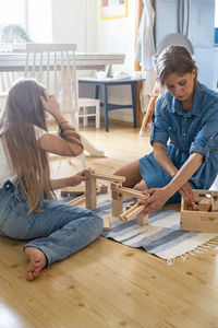 Young woman sitting on wooden floor