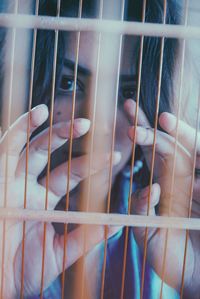 Close-up portrait of woman seen through window