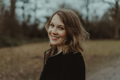 Portrait of smiling young woman standing outdoors