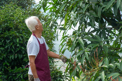 Side view of woman standing by plants