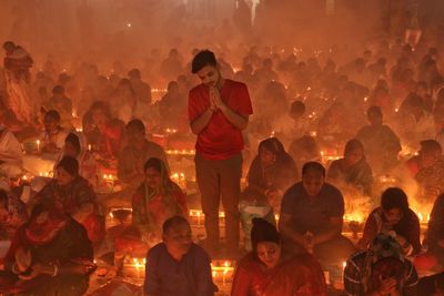 Praying at rakher upobash infront of burning candle and incense