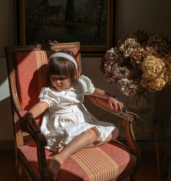 French morning. girl is sitting on a vintage chairs in front of window