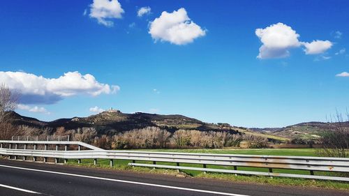 Road by mountain against blue sky