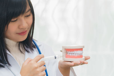 Dentist injecting syringe in teeth model