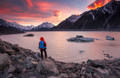 Rear view of man overlooking calm lake