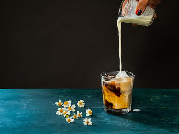 Close-up of drink in glass on table against black background