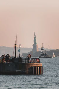 Statue in sea against clear sky