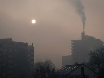 Smoke emitting from chimney against sky