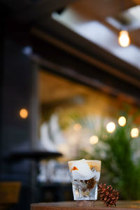 Close-up of drink in glass by pine cone on table