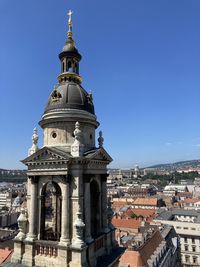 View of buildings in city against clear blue sky