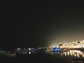 Illuminated city against sky at night