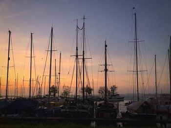 Sailboats in sea at sunset