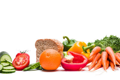 Fruits and vegetables on plate against white background
