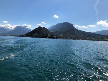 Scenic view of sea by mountains against sky