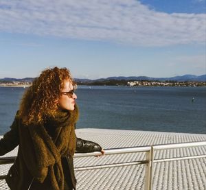 Woman looking away against sea on sunny day