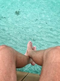 Low section of man relaxing in swimming pool