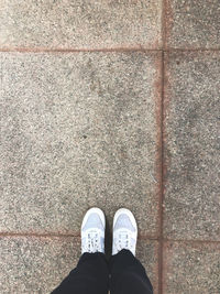 Low section of man standing on tiled floor