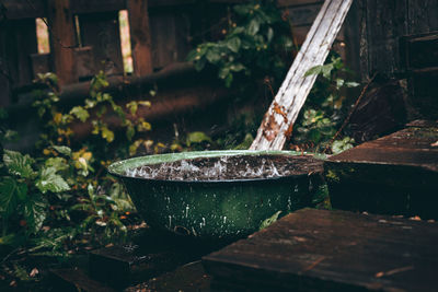 Vintage green water bowl under the rain. late autumn 