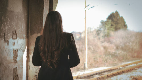 Rear view of woman standing against built structure