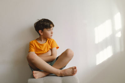 Cute boy sitting barefoot in a home. beautiful light.