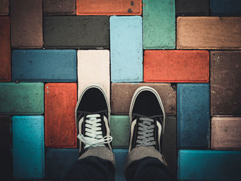 Low section of man standing on tiled floor