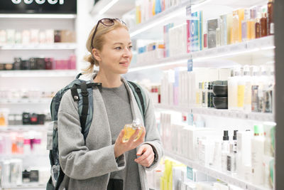 Smiling woman standing in front of store