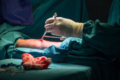 Midsection of person holding hands on cutting board