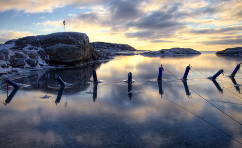 Scenic view of frozen lake against sky during sunset