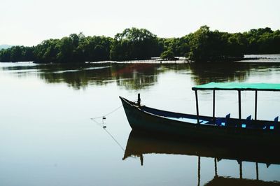 Boat moored in lake against sky