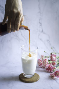 Iced black tea with milk. thai ice tea with milk on wood disk in marble background.