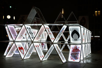 Low angle view of illuminated text on table against building