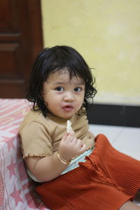 Portrait of cute girl sitting at home