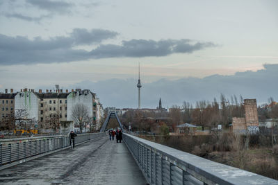 People walking on footbridge in city