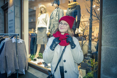 Woman standing by street in city during winter