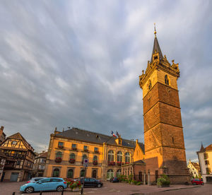 Low angle view of buildings against cloudy sky