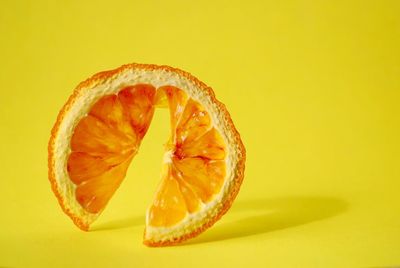 Close-up of orange fruit against yellow background