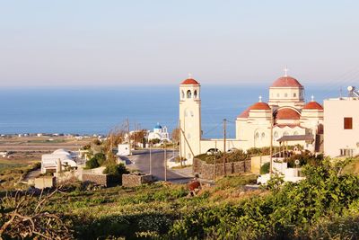 High angle view of historic church by sea against clear sky