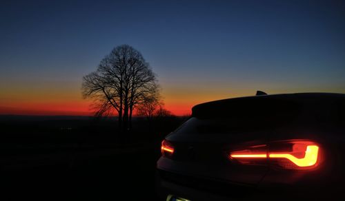Silhouette of car against sky during sunset