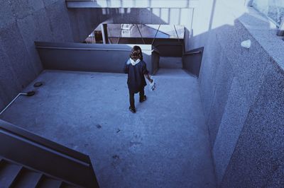 High angle view of woman walking towards stairs