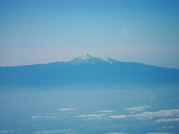 Scenic view of snowcapped mountains against blue sky