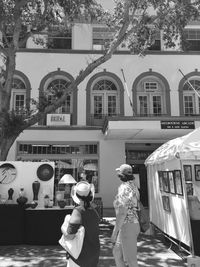 Rear view of people walking in front of building