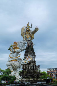 Statue of angel against sky