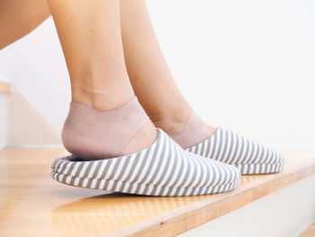 Low section of woman standing on wooden floor